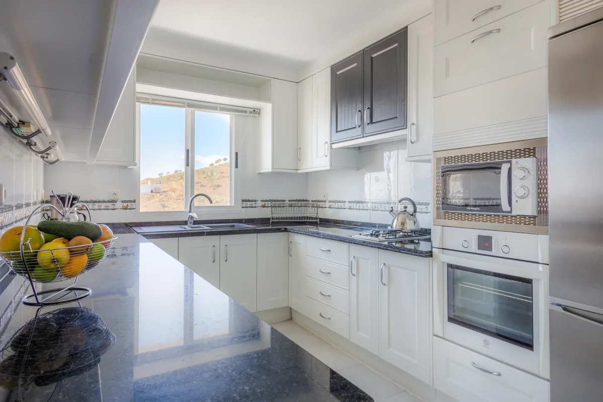 Keuken met kookplaat, oven, magnetron en afwasmachine