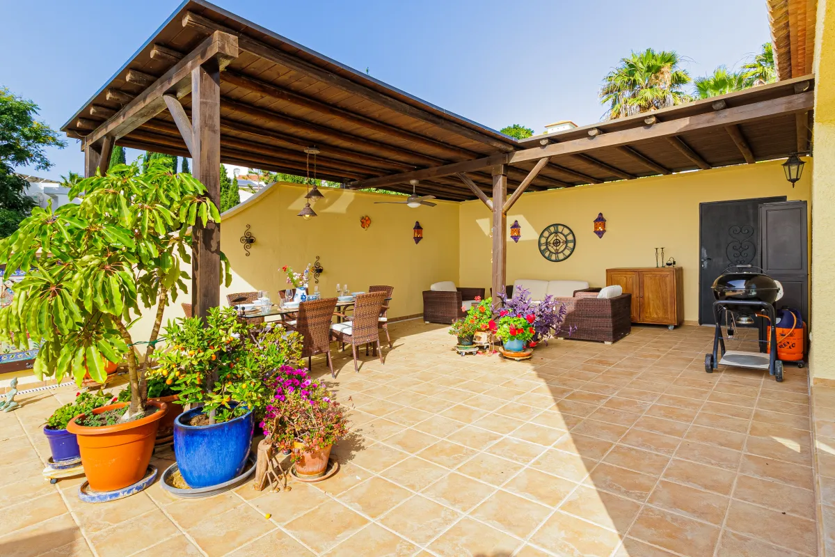 Überdachte Terrasse mit Loungegruppe, Esstisch und Grill