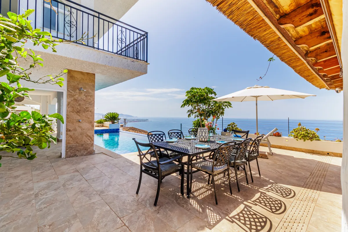 Esstisch im Freien auf der Terrasse neben dem Pool