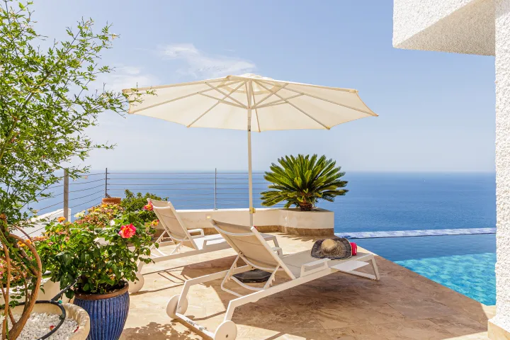 Sonnenliegen am Pool mit Blick auf das Mittelmeer